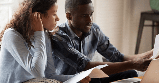 husband and wife looking at bills together