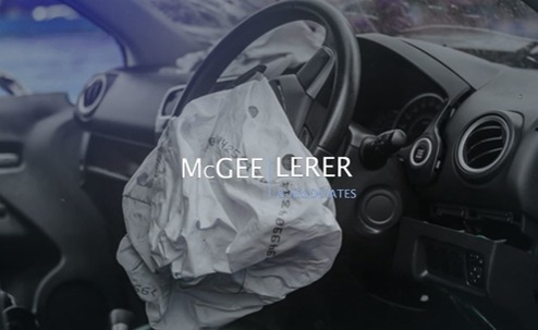 The image shows the interior of a wrecked car, focusing on the deployed airbag. Text overlay reads "McGee Lerer & Associates".