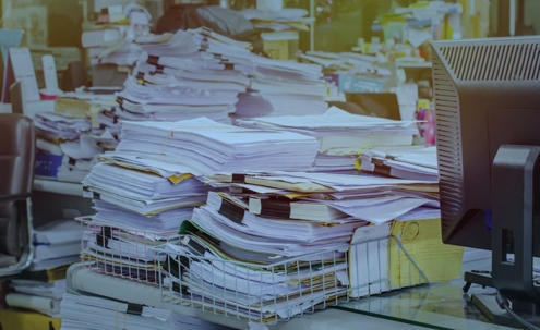 Desk piled up with files and paper