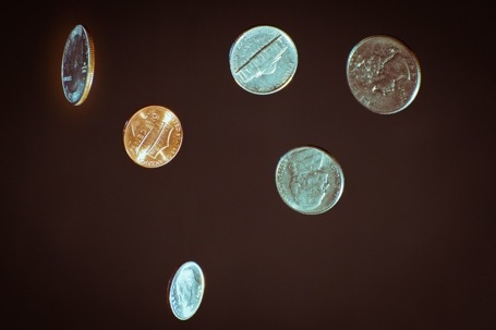 It features a variety of US coins seemingly floating against a dark backdrop.