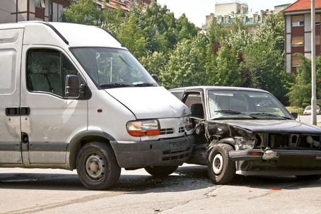 A white van and a gray car that have collided.