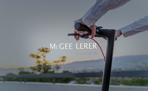 An individual grips the handles of an electric scooter