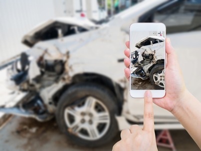 picture of a wrecked car with a mobile phone