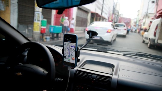 car view with a dashboard and a phone displaying a map.