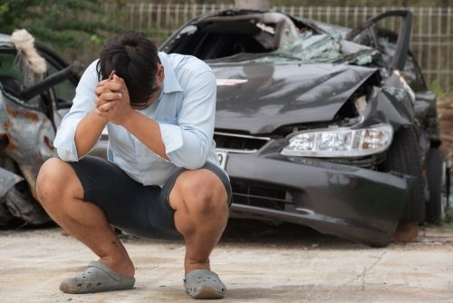 a man thinking about his wrecked vehicle