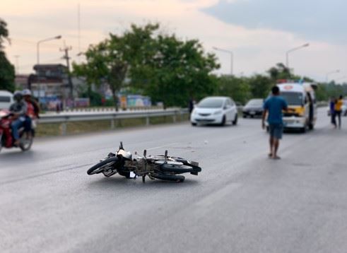 broken motorcycle laying in road after crash